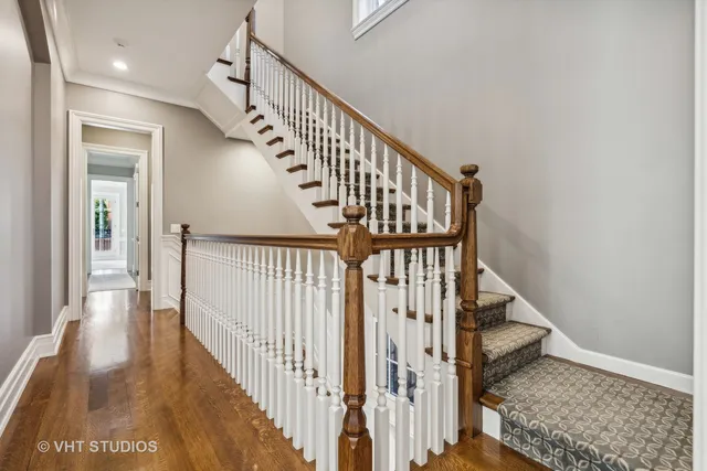 a view of a hallway with wooden floor and staircase