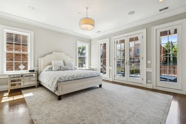 a spacious bedroom with a large bed and a flat tv screen on dresser