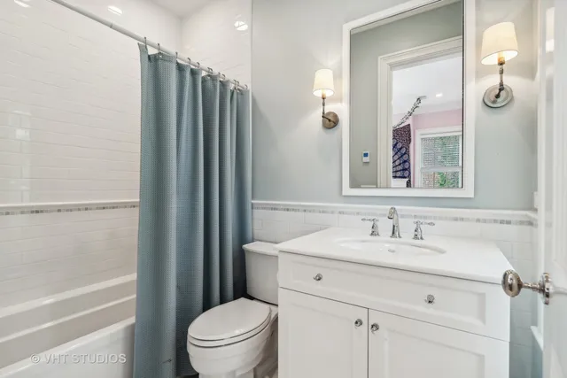 a bathroom with a granite countertop toilet sink and mirror