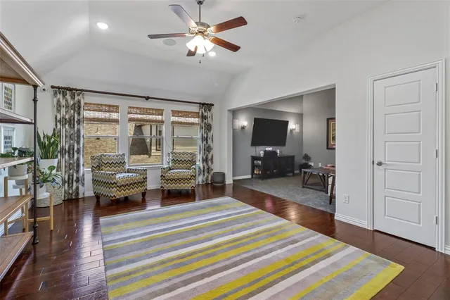 a spacious bedroom with a bed and wooden floor