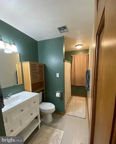 a bathroom with a toilet a sink and mirror