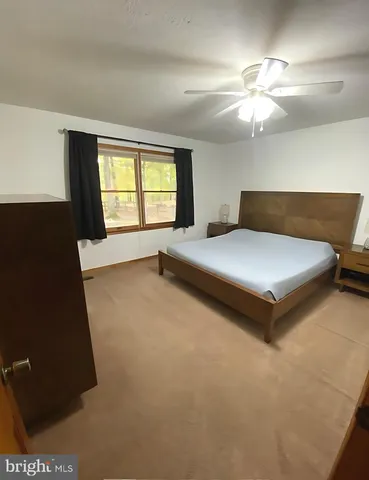 a spacious bedroom with a bed and window