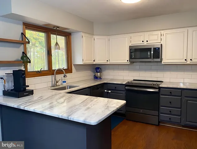 a kitchen with stainless steel appliances granite countertop a sink stove and cabinets