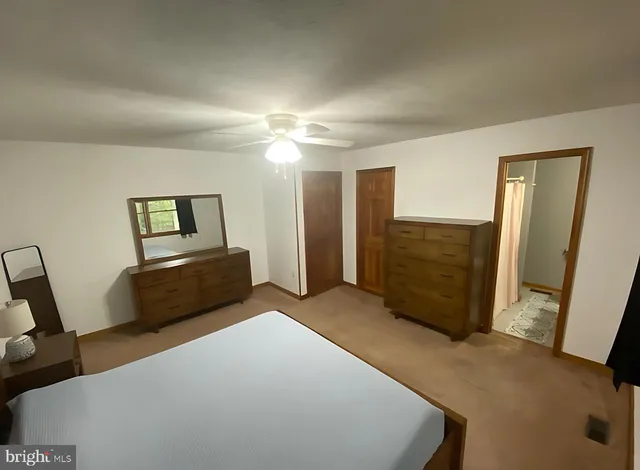 a spacious bedroom with a bed and a chandelier