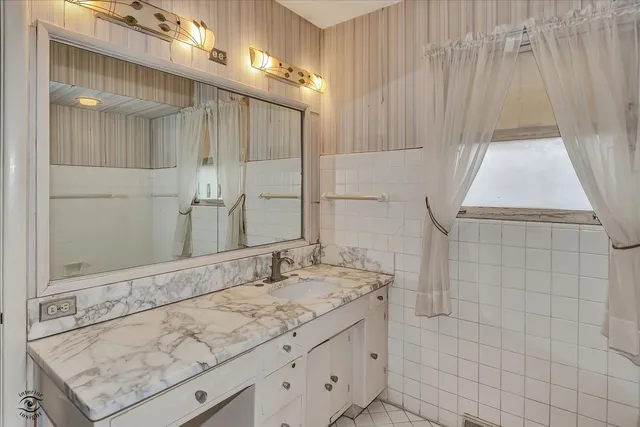 a bathroom with a granite countertop sink and a mirror