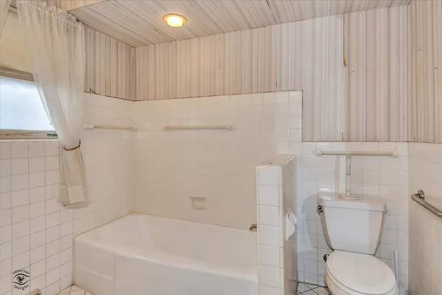 a bathroom with a toilet and bathtub