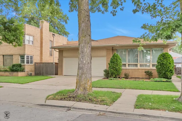 a front view of a house with a yard and potted plants