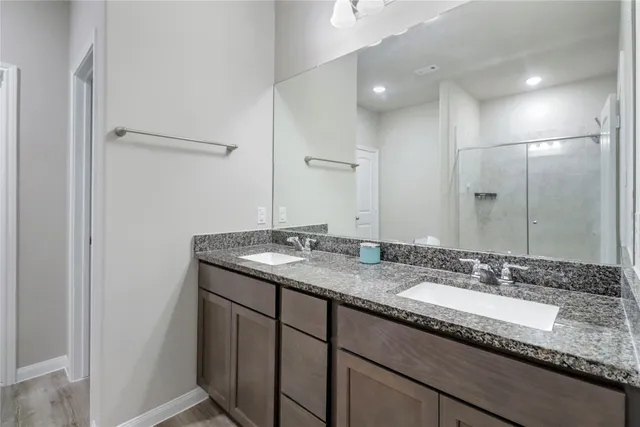 a bathroom with a granite countertop sink double and mirror