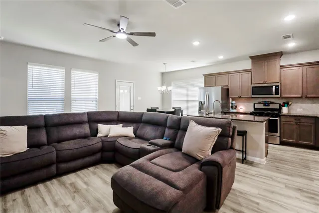 a living room with furniture kitchen and a wooden floor