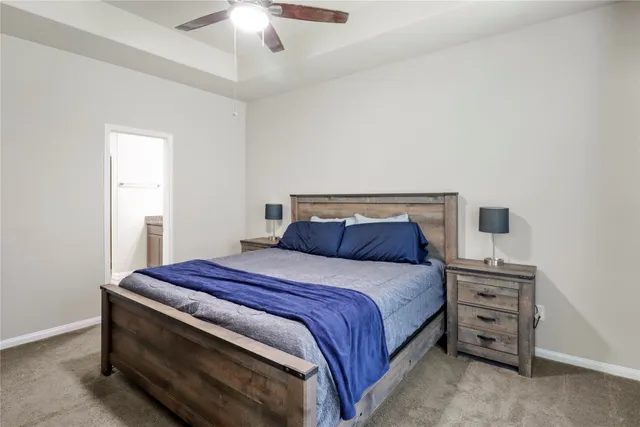 a bed sitting in a bedroom next to a window and a chandelier