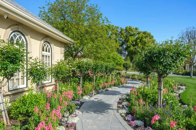 a front view of a house with a yard and fountain