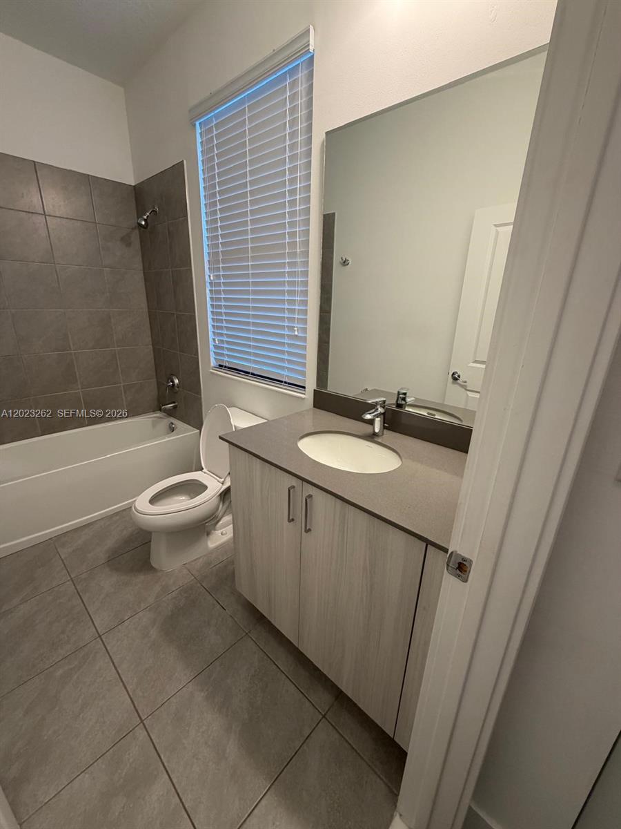 5669 Cerva Lane, Unit 5669 Immokalee, FL 34142 - Photo 12 of 32 a bathroom with a granite countertop sink toilet and shower