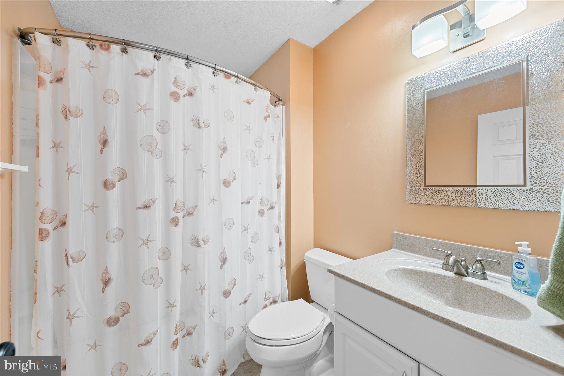 11 Amanda's Court Ocean View, DE 19970 - Photo 34 of 42 a bathroom with a granite countertop sink a toilet and a mirror