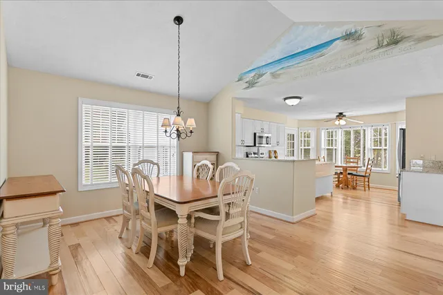a dining room with furniture a chandelier and wooden floor