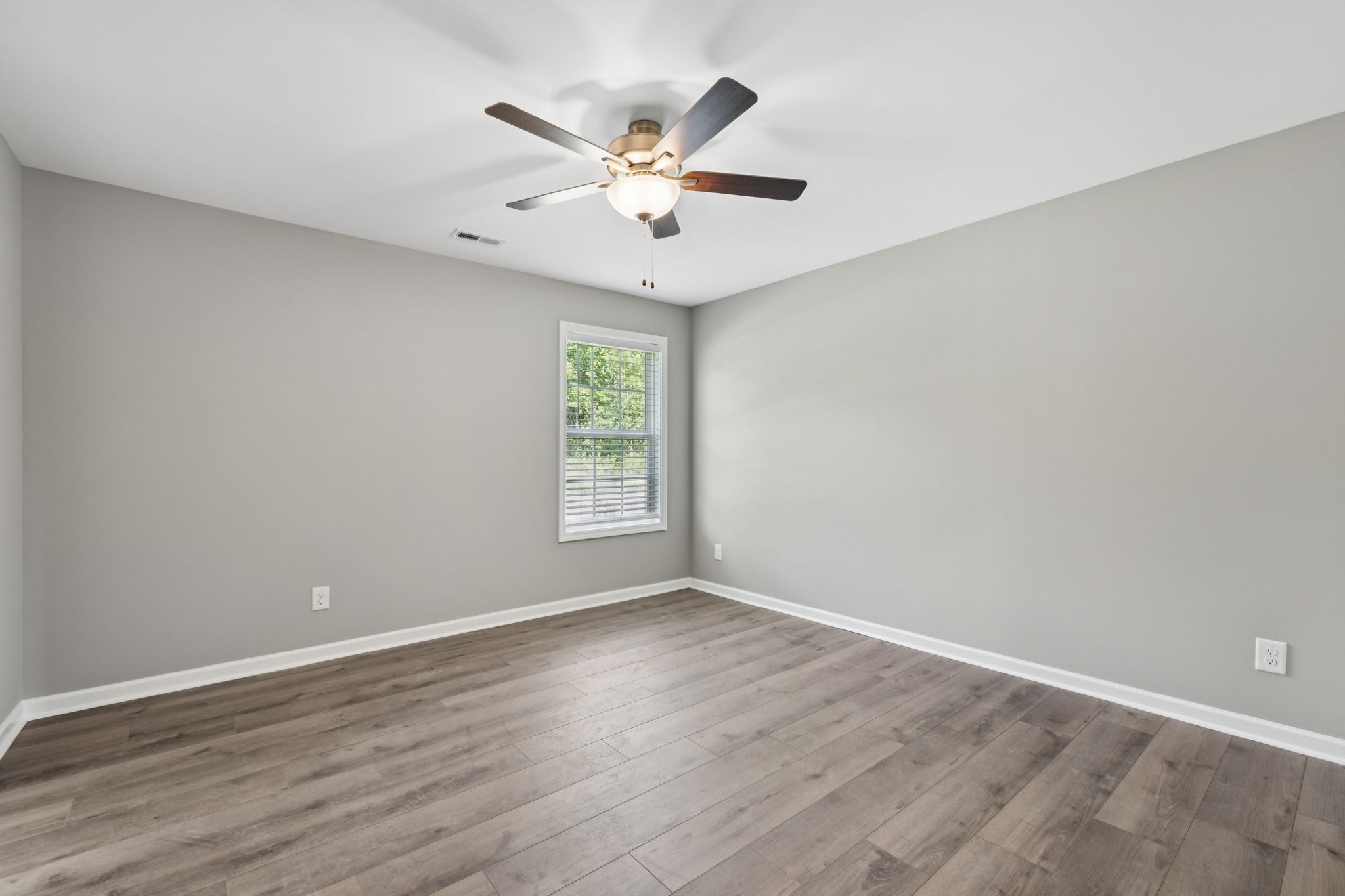 84 Old Brick Church Road Estill Springs, TN 37330 - Photo 25 of 37 an empty room with wooden floor fan and windows
