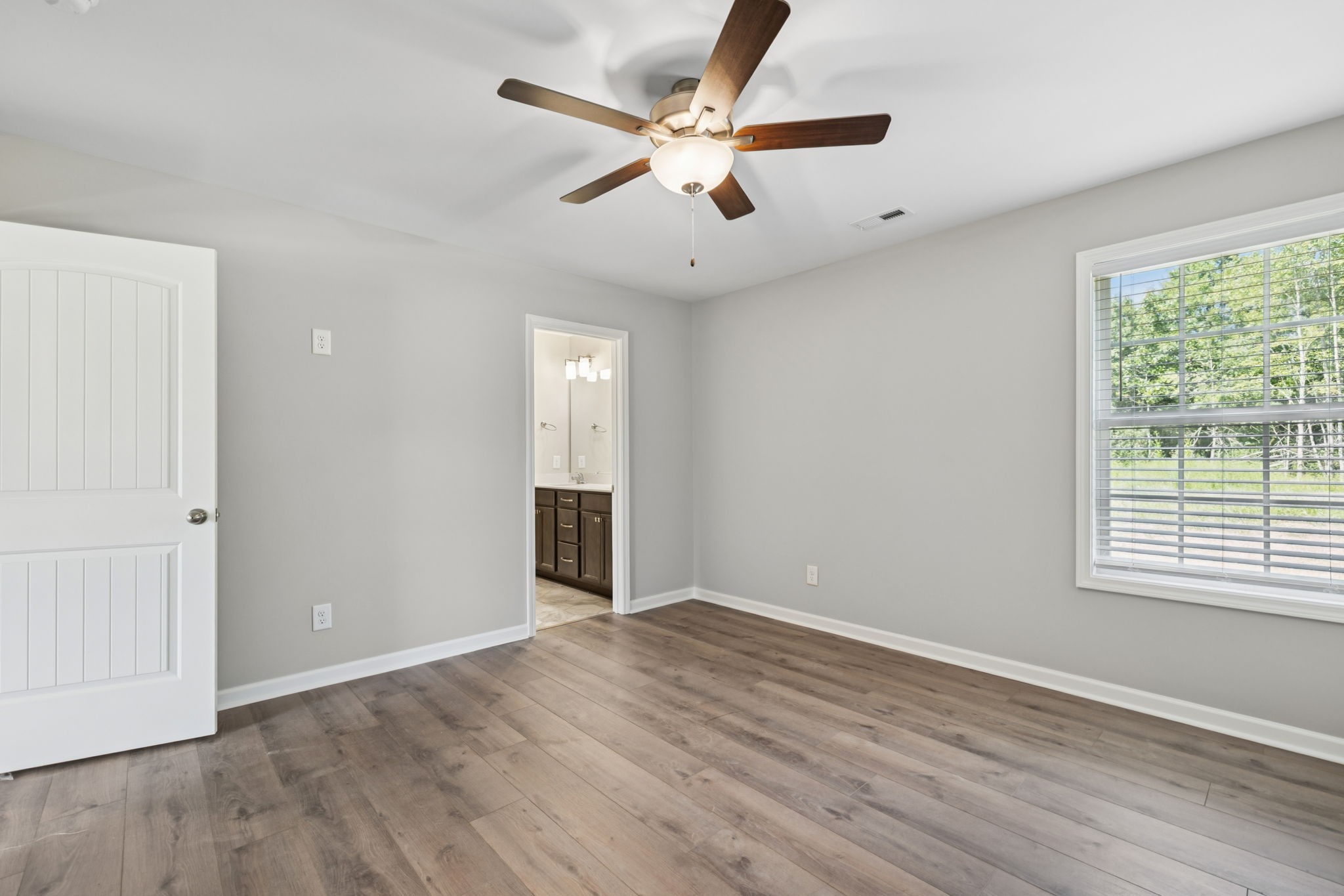 84 Old Brick Church Road Estill Springs, TN 37330 - Photo 26 of 37 an empty room with wooden floor chandelier fan and windows