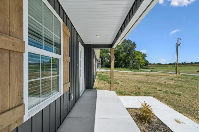 a view of empty room with wooden floor and window