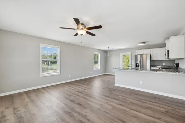 a view of a kitchen with a sink and dishwasher a refrigerator with wooden floor