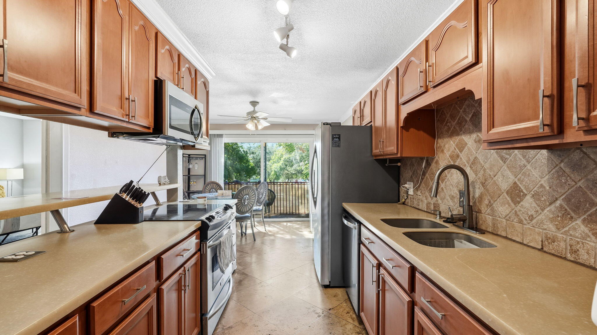 210 Pelham Road, Unit 215A Fort Walton Beach, FL 32547 - Photo 20 of 27 a kitchen with stainless steel appliances granite countertop a sink a stove and a wooden floors