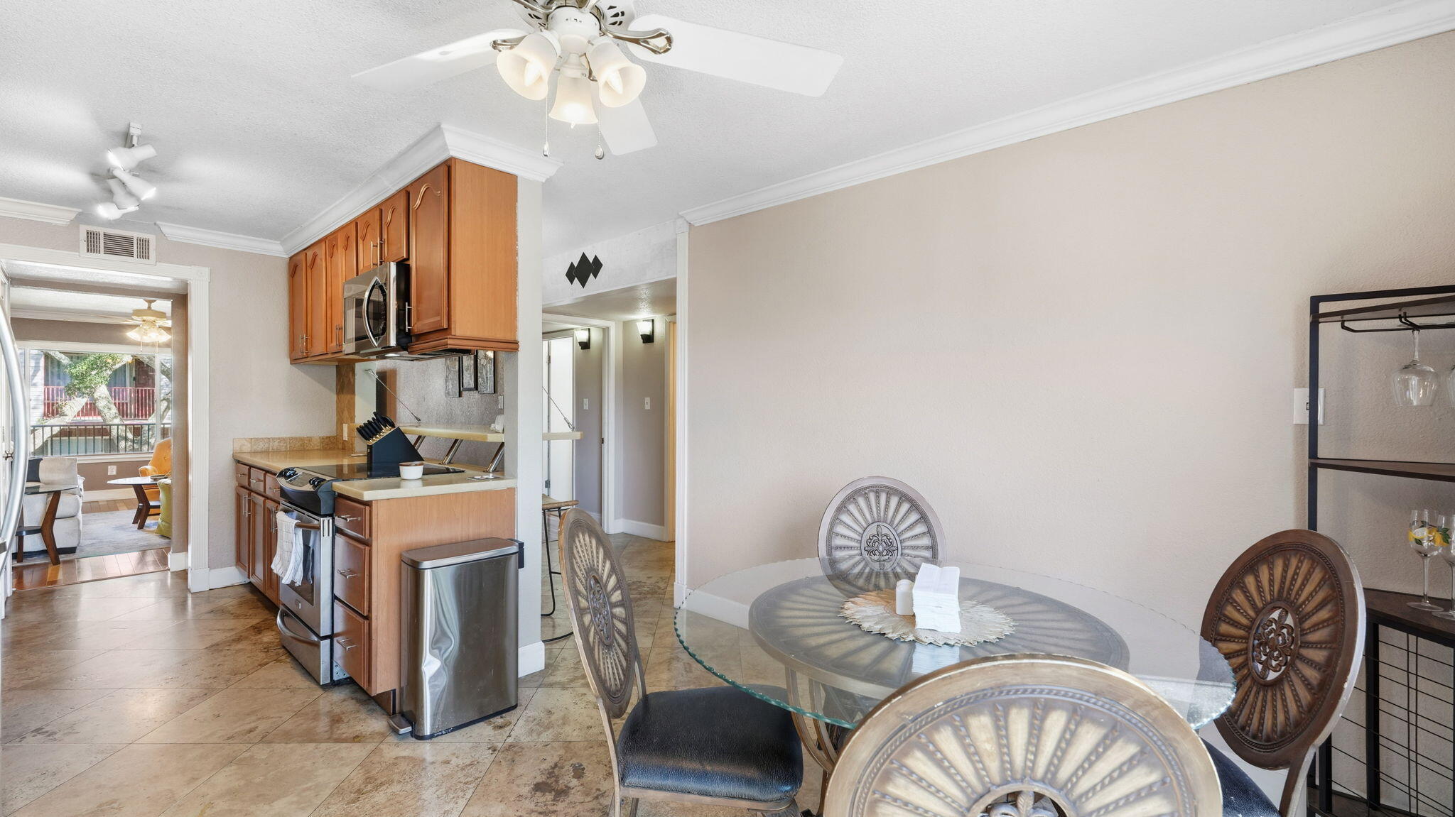 210 Pelham Road, Unit 215A Fort Walton Beach, FL 32547 - Photo 22 of 27 a kitchen with stainless steel appliances granite countertop a stove top oven a sink a dining table and chairs with wooden floor