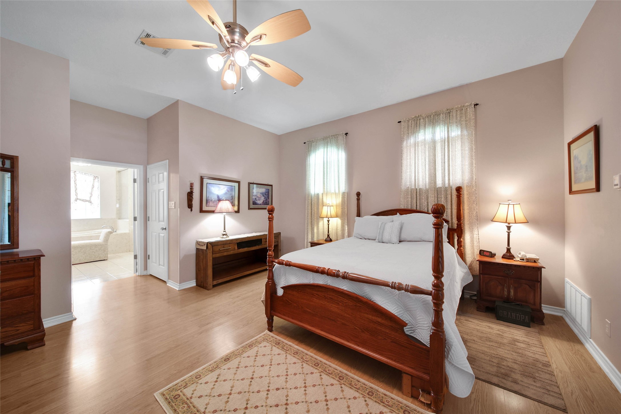 128 Duke Road Bedias, TX 77831 - Photo 18 of 50 a spacious bedroom with a bed a chandelier and a couch