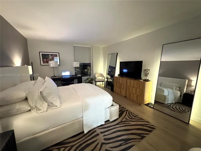 a bedroom with a bed and a flat screen tv