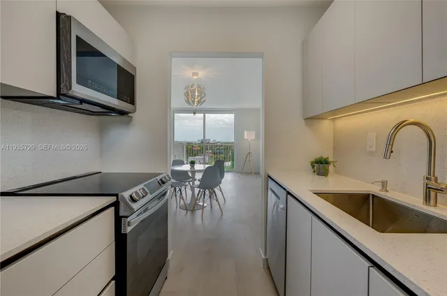 a kitchen with stainless steel appliances a stove a sink and a microwave