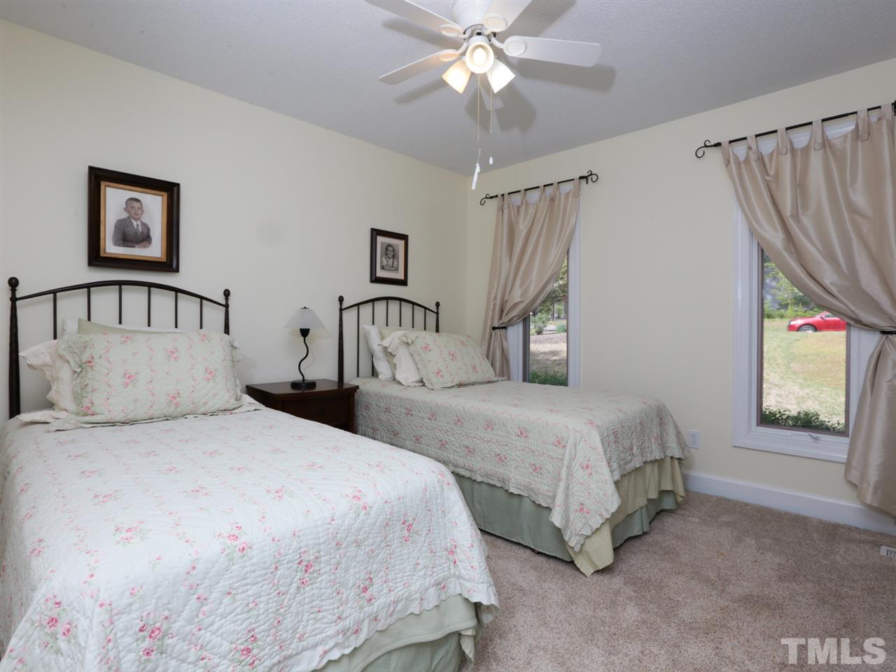 7309 Phellos Court Raleigh, NC 27615 - Photo 12 of 19 a bedroom with a bed and a chandelier