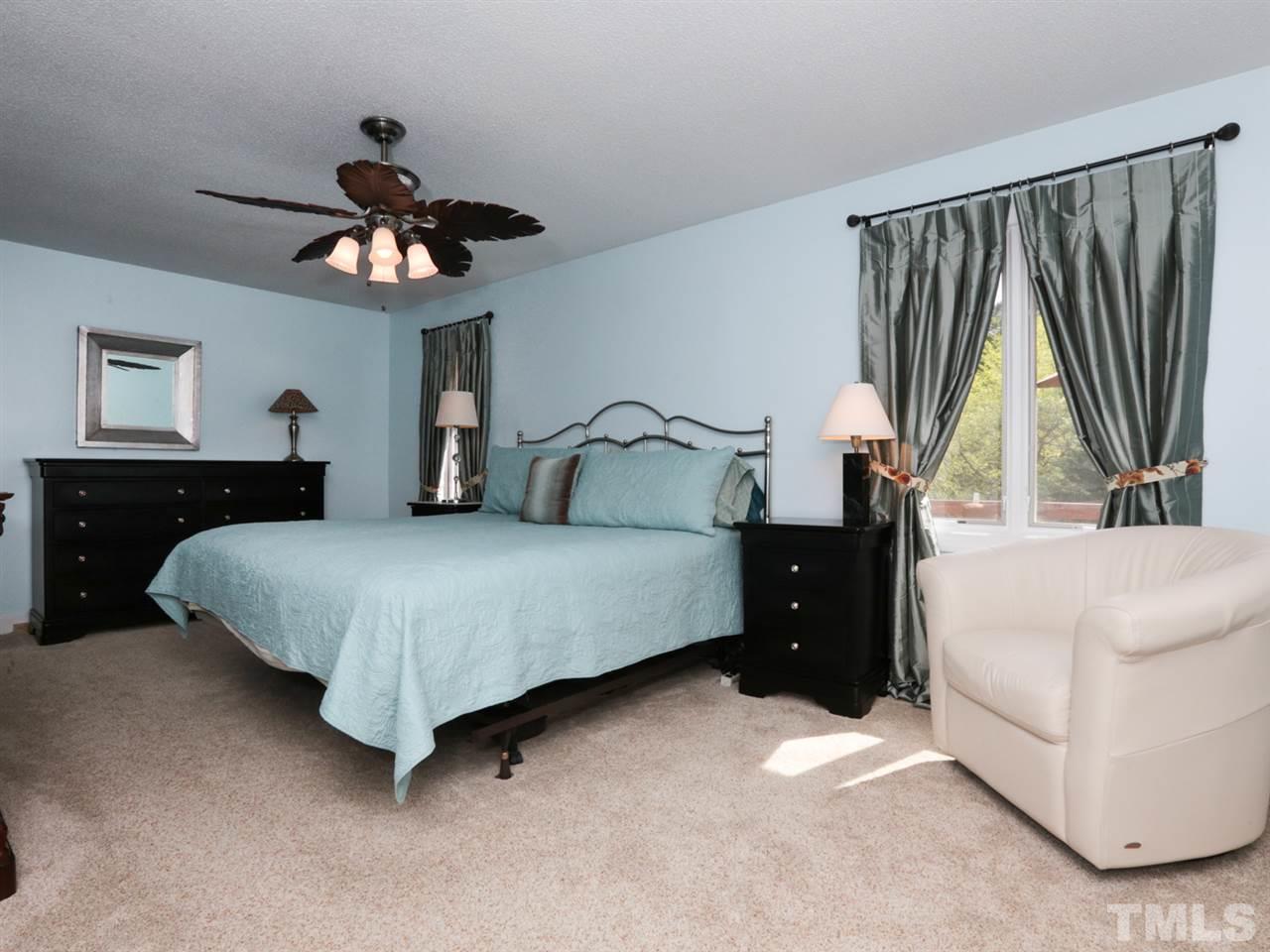 7309 Phellos Court Raleigh, NC 27615 - Photo 15 of 19 a bedroom with a large bed and a chandelier
