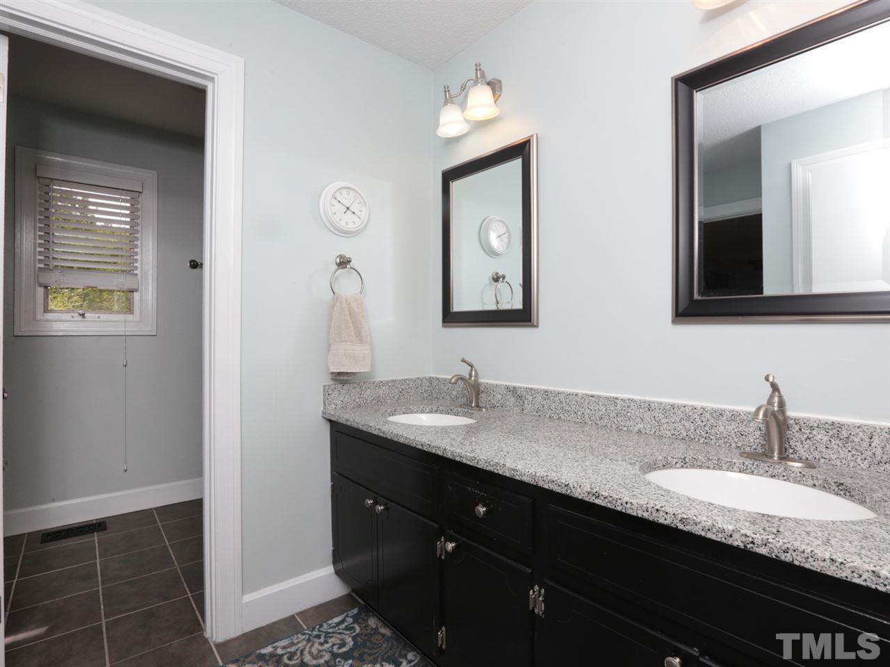 7309 Phellos Court Raleigh, NC 27615 - Photo 16 of 19 a bathroom with a granite countertop sink and a mirror