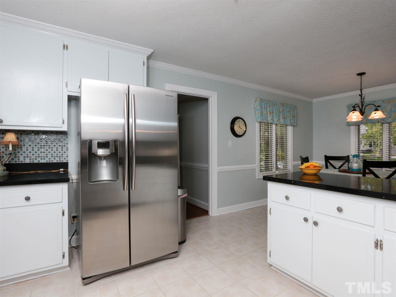 7309 Phellos Court Raleigh, NC 27615 - Photo 7 of 19 a kitchen with stainless steel appliances a refrigerator sink and white cabinets