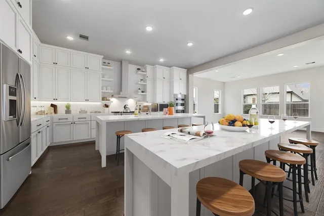 a kitchen with a sink a stove a center island and chairs