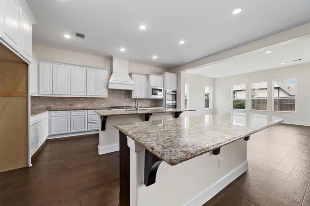 a kitchen with stainless steel appliances granite countertop a sink stove and cabinets