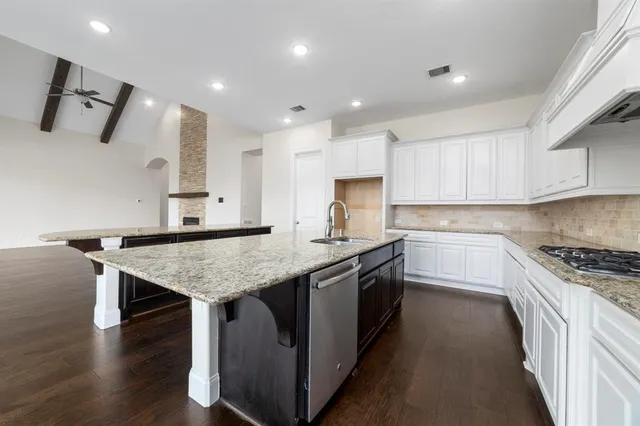 a kitchen with stainless steel appliances granite countertop a stove sink refrigerator and cabinets