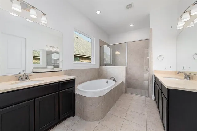 a bathroom with a tub sink and mirror