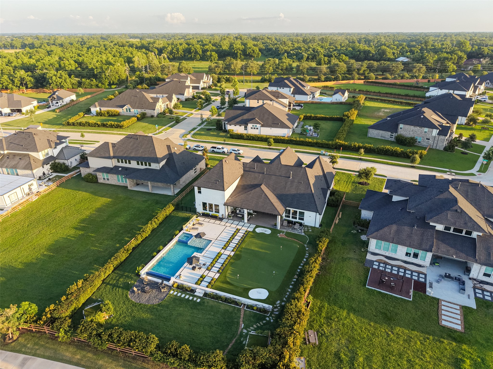 29612 Fulshear Lake Trace Fulshear, TX 77406 - Photo 7 of 48 This aerial photo showcases a suburban neighborhood with spacious, modern homes and well-maintained lawns. The featured property includes a backyard with a large pool, a patio area, and ample green space, offering a blend of luxury and comfort. The surrounding area is lush with greenery, providing a serene and inviting atmosphere.