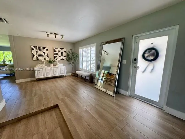 a view of a livingroom with wooden floor and a ceiling fan