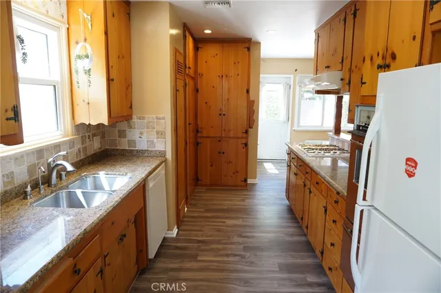 a bathroom with sink a mirror and wooden floor