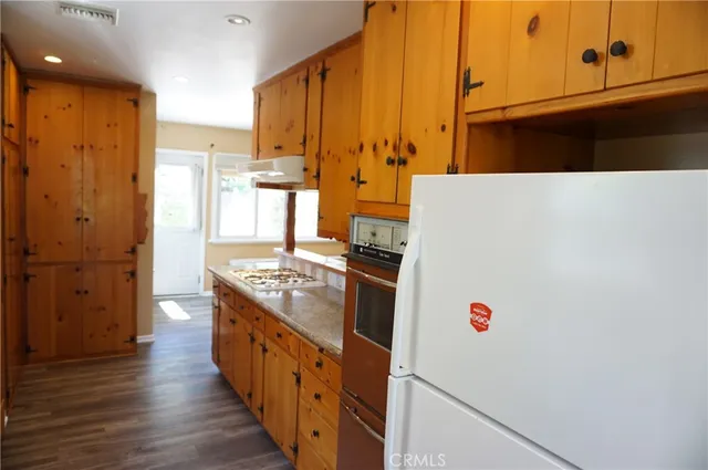 a view of a kitchen with wooden floor and a window