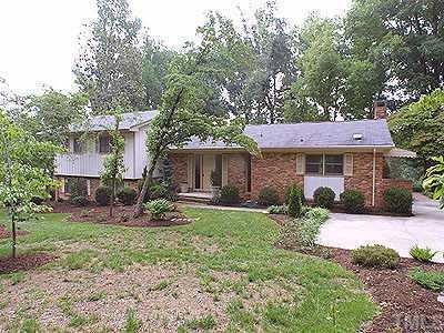 a front view of a house with a yard and trees