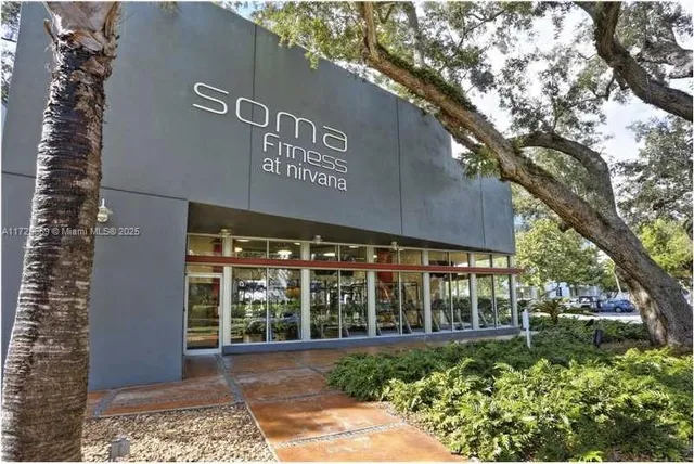 a view of a black and white house with a large tree