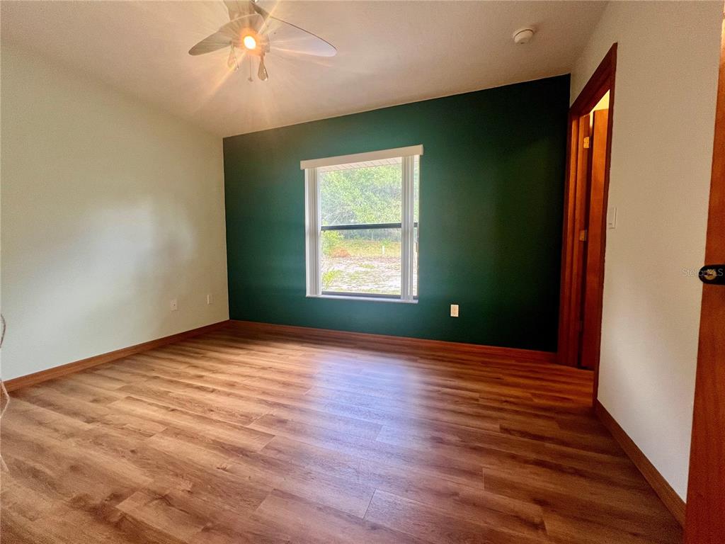 1156 South Carpenter Avenue Orange City, FL 32763 - Photo 19 of 21 a view of an empty room with wooden floor and a window