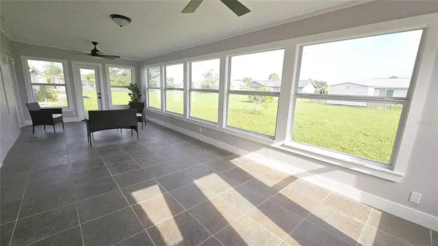 a living room filled with furniture and large windows
