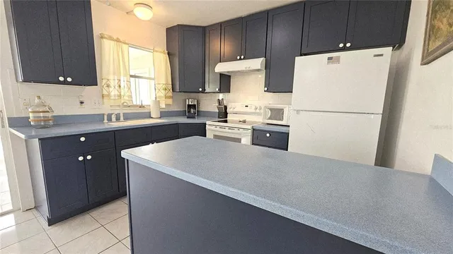 a kitchen with refrigerator cabinets and white appliances
