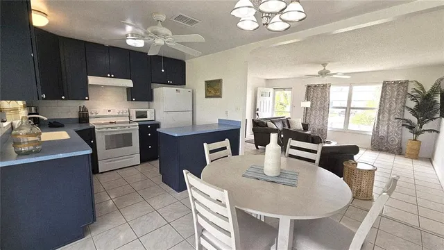 a kitchen with stainless steel appliances granite countertop a stove a sink a dining table and chairs