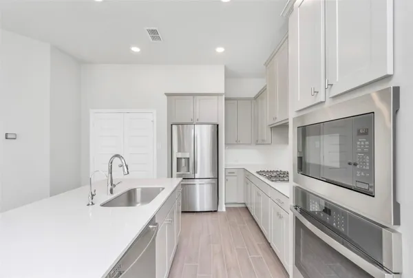 a kitchen with stainless steel appliances granite countertop a refrigerator and a sink
