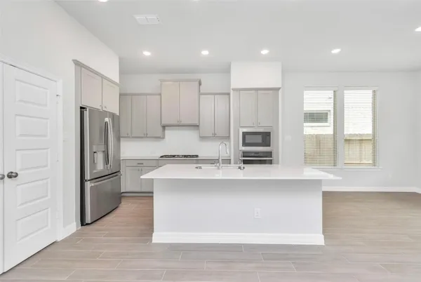 a kitchen with kitchen island a sink stove and refrigerator