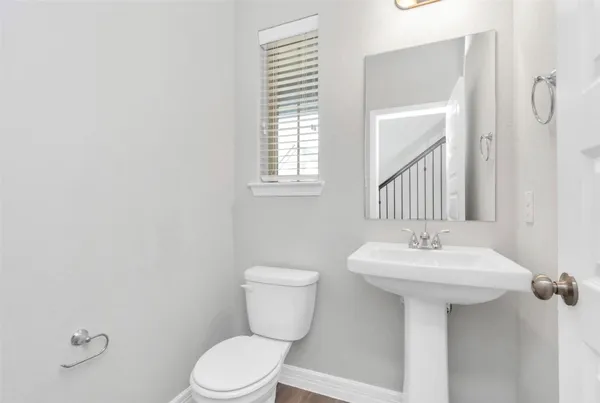 a bathroom with a sink toilet and mirror