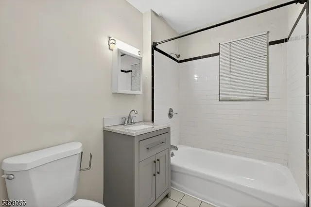 a bathroom with a granite countertop sink a toilet and shower