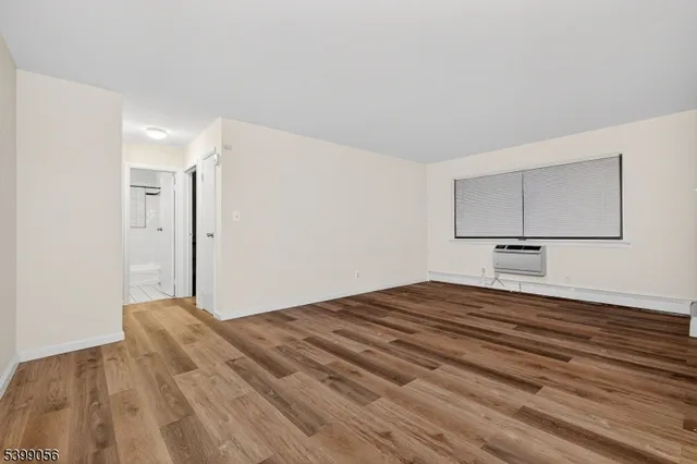 a view of a livingroom with wooden floor and cabinet